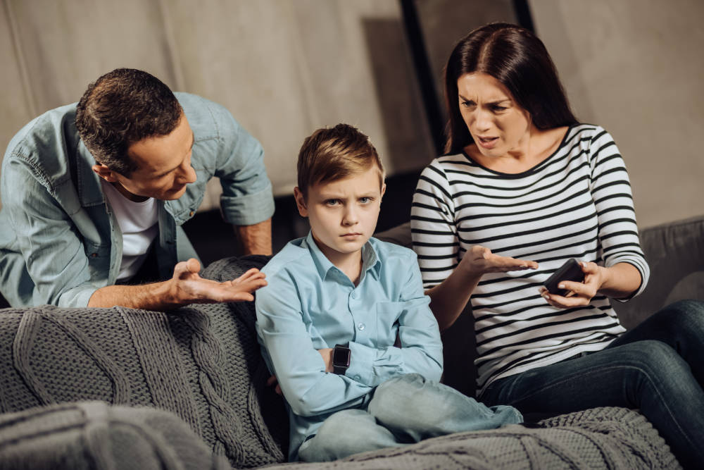 Eltern diskutieren mit ihrem Sohn über Handynutzung